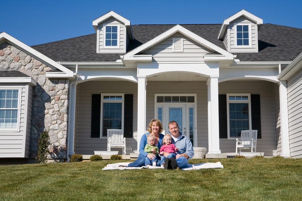 Happy Family in Front of Their Home